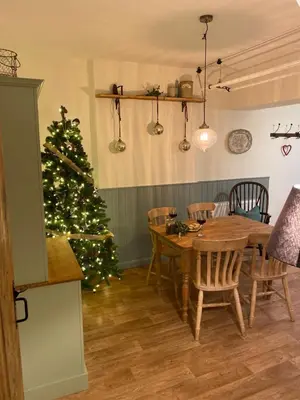 a christmas tree in a room with a table and chairs at The Stopping Point- Exceptional Cumbrian Cottage in Flookburgh