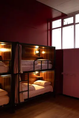 two bunk beds in a room with red walls at Malacuna Liverpool in Liverpool