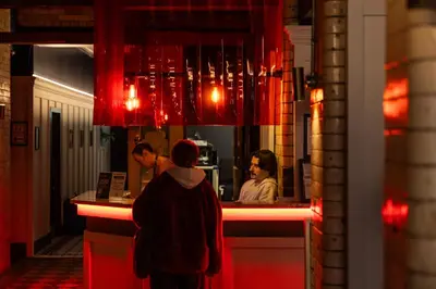 a group of people standing at a counter in a restaurant at Malacuna Liverpool in Liverpool