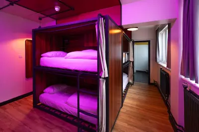 two bunk beds in a room with pink lighting at Malacuna Liverpool in Liverpool