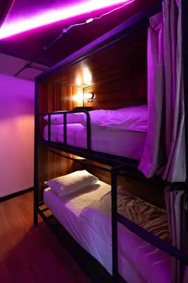 two bunk beds in a room with purple lights at Malacuna Liverpool in Liverpool