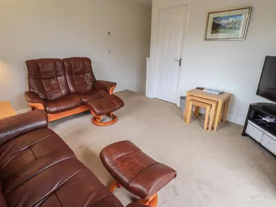 a living room with a couch and chairs and a television at Shore View in Grange Over Sands