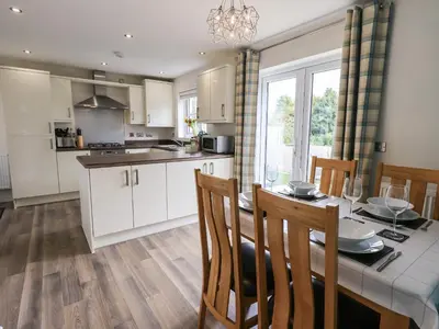 a kitchen and dining room with a table and chairs at Shore View in Grange Over Sands