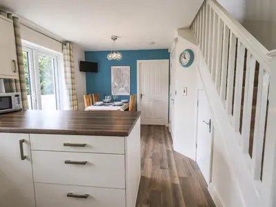 a kitchen with a counter top and a staircase at Shore View in Grange Over Sands