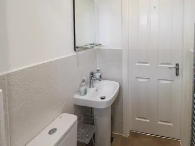 a bathroom with a sink and a mirror and a toilet at Shore View in Grange Over Sands