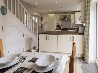 a kitchen with a table with wine glasses on it at Shore View in Grange Over Sands