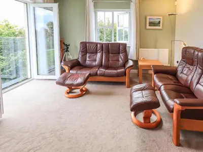 a living room with leather furniture and a couch at Shore View in Grange Over Sands