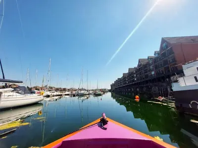 a person sitting on the edge of a boat in the water at The Joker Boat in Liverpool