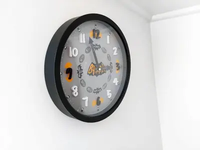 a black clock hanging on a white wall at The Joker Boat in Liverpool
