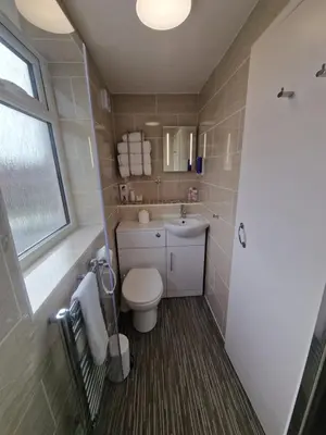 a bathroom with a toilet and a sink and a window at Corona Blackpool in Blackpool
