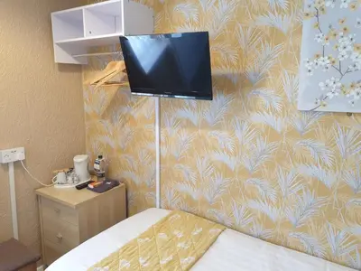 a room with a bed and a tv on a wall at Corona Blackpool in Blackpool