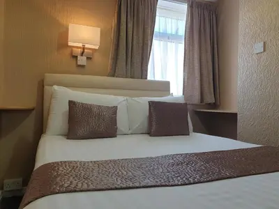 a bedroom with a bed with pillows and a window at Corona Blackpool in Blackpool