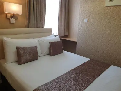 a hotel room with a bed with two pillows at Corona Blackpool in Blackpool