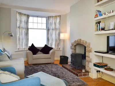 a living room with a couch and a fireplace at Lythdene in Grange Over Sands