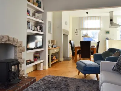 a living room with a fireplace and a dining room at Lythdene in Grange Over Sands