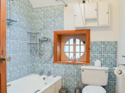 a bathroom with a tub and a toilet and a sink at Lythdene in Grange Over Sands