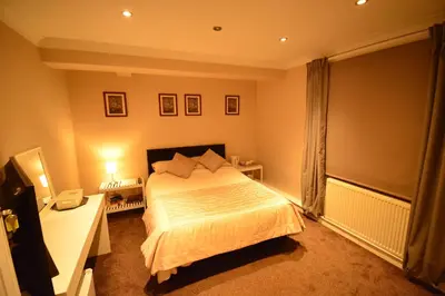 a bedroom with a bed and a desk and a window at Aparthotel Glovers Court in Preston