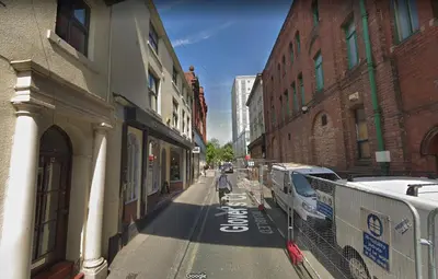 an empty street in a city with buildings at Aparthotel Glovers Court in Preston