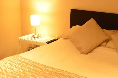 a bedroom with a bed with a table with a lamp at Aparthotel Glovers Court in Preston