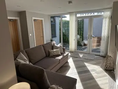 a living room with a brown couch and sliding glass doors at Beach Pad - ground floor - pet friendly in Cleveleys