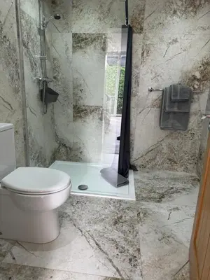 a bathroom with a toilet and a glass shower at Beach Pad - ground floor - pet friendly in Cleveleys
