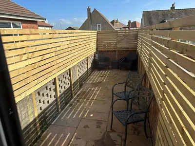 a patio with two chairs and a fence at Beach Pad - ground floor - pet friendly in Cleveleys