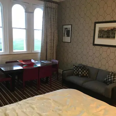 a living room with a couch and a table and a desk at Aberley House in Liverpool