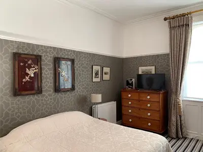 a bedroom with a bed and a dresser and a television at Aberley House in Liverpool