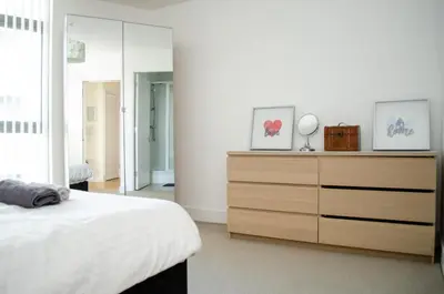 a bedroom with a bed and a dresser with a mirror at Ropewalks Apartments by Happy Days in Liverpool