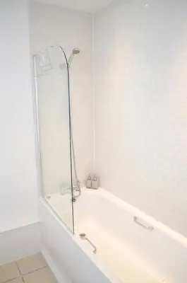 a white bath tub with a shower in a bathroom at Ropewalks Apartments by Happy Days in Liverpool