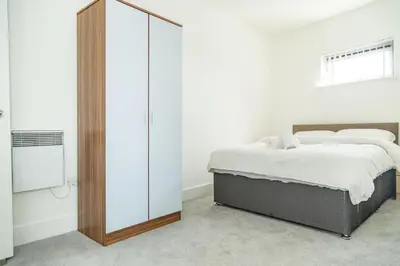 a bedroom with a bed and a large glass closet at Ropewalks Apartments by Happy Days in Liverpool