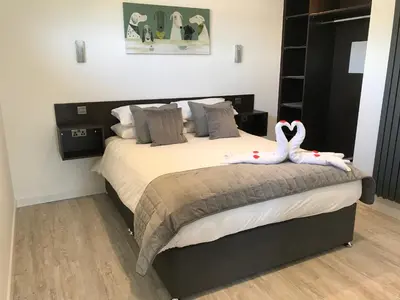 a bedroom with a bed with two swans on it at Parkknott Retreat Luxury Lodge with Private Hot Tub in Askam in Furness
