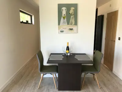 a dining room with a black table and chairs at Parkknott Retreat Luxury Lodge with Private Hot Tub in Askam in Furness