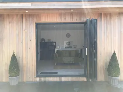 a living room with a couch and two trees at Parkknott Retreat Luxury Lodge with Private Hot Tub in Askam in Furness