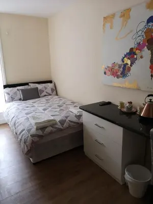 a bedroom with a bed and a dresser and a desk at The Winter Garden Suites in Blackpool