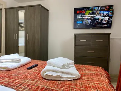 a bedroom with a bed with towels and a tv at Simpson Beach View Apartments by Blackpool Service Apartments in Blackpool