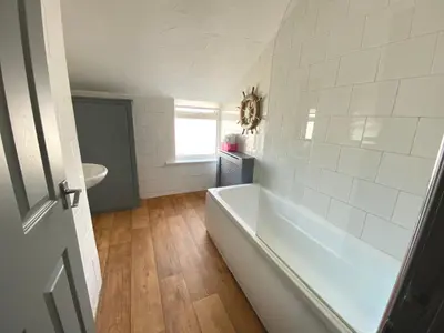 a white bathroom with a tub and a sink at Simpson Beach View Apartments by Blackpool Service Apartments in Blackpool
