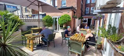a group of people sitting at tables on a patio at Fairhaven Hotel in Blackpool