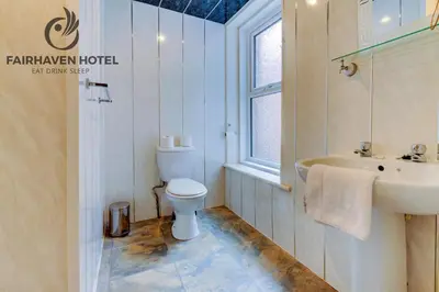 a bathroom with a toilet and a sink at Fairhaven Hotel in Blackpool