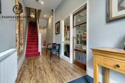 a hallway with a red staircase in a house at Fairhaven Hotel in Blackpool
