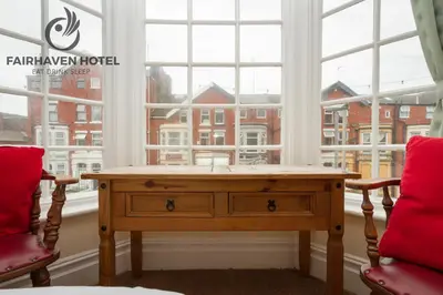 a room with a wooden table in front of a window at Fairhaven Hotel in Blackpool