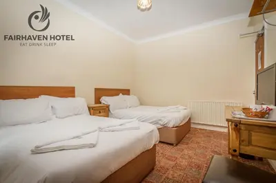 a hotel room with two beds and a tv at Fairhaven Hotel in Blackpool