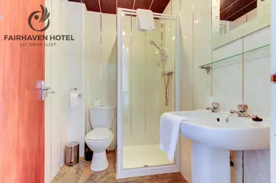 a bathroom with a toilet and a sink and a shower at Fairhaven Hotel in Blackpool