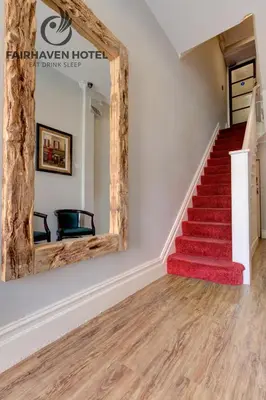 a staircase in a house with a mirror at Fairhaven Hotel in Blackpool