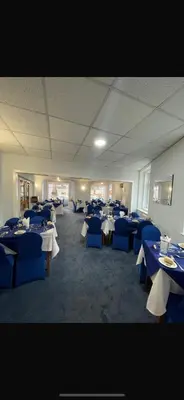 a room with tables and chairs with blue tables at Silversands Hotel in Blackpool