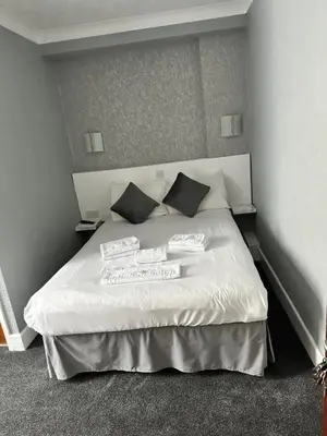a bedroom with a white bed with two pillows at Silversands Hotel in Blackpool