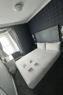 a bedroom with a large white bed with a window at Silversands Hotel in Blackpool