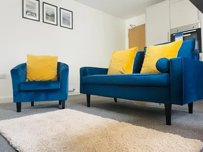 a blue couch and two yellow pillows in a living room at The Seacroft in Southport