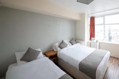 a bedroom with two beds and a window at MyRoomz Hollingdales Hotel in Blackpool