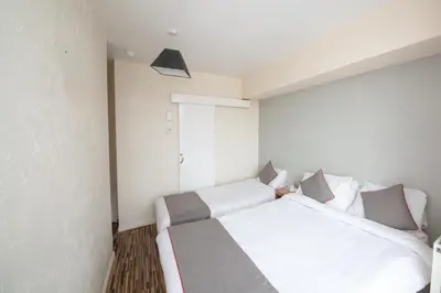 a bedroom with two white beds in a room at MyRoomz Hollingdales Hotel in Blackpool